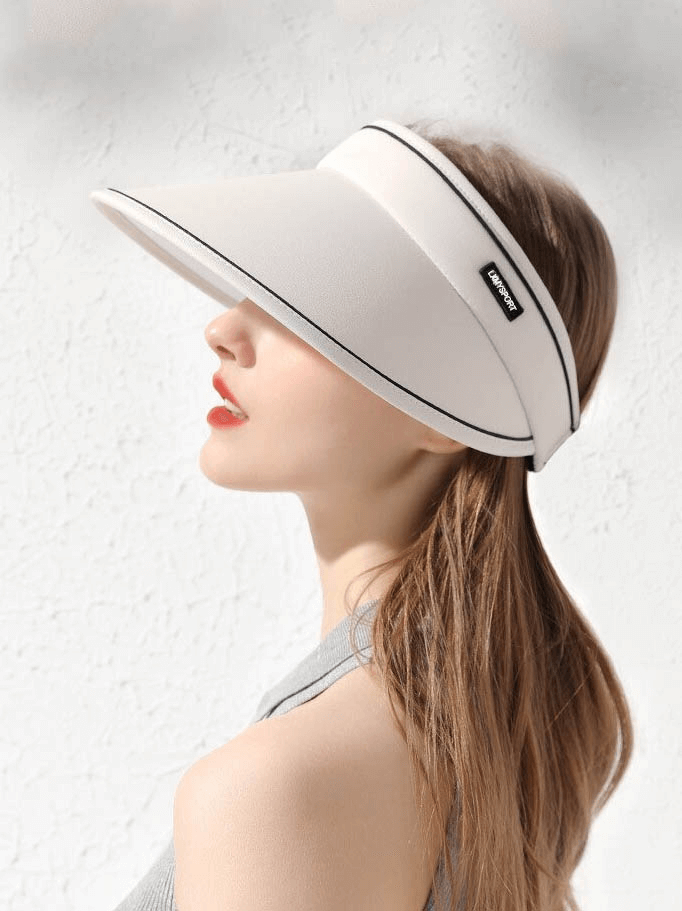 Woman wearing adjustable sun proof hollow visor cap, stylish foldable design in white, offering sun protection; perfect for outdoor activities.